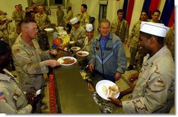 President George W. Bush meets with troops and serves Thanksgiving Dinner at the Bob Hope Dining Facility, Baghdad International Airport, Iraq,, Thursday, November 27, 2003. White House photo by Tina Hager.