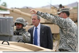 President George W. Bush watches as a soldier operates technical field equipment, joined by U.S. Army Captain Pat Armstrong, right, during President Bushs visit to the U.S. Army National Training Center Wednesday, April 4, 2007, at Fort Irwin, Calif.  White House photo by Eric Draper